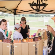 people looking at Sunrise Farms products under a tent